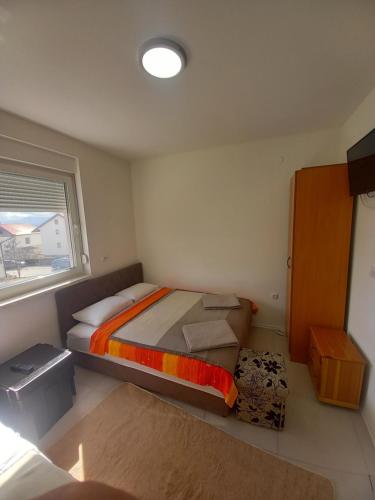 - une petite chambre avec un lit et une fenêtre dans l'établissement Apartmani Herceg, à Gacko