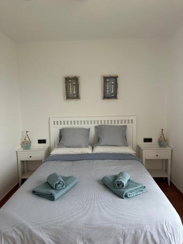 Una cama blanca con dos toallas encima. en Villa Alex Altafulla Hermosa casa con espectaculares vistas al mar y a tocar de una idílica calita, en Altafulla