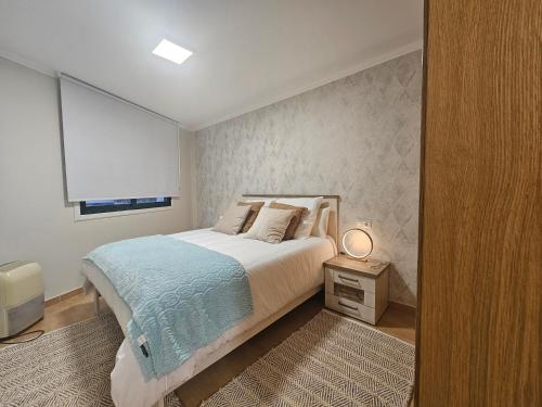 - une chambre avec un grand lit et une fenêtre dans l'établissement Apartamento Nara Playa, à Boiro