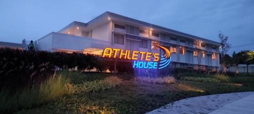 a building with a sign in front of a house at Athlete's House in Imus