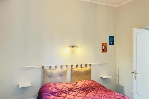 Un dormitorio con una cama con un edredón rojo. en Les chats maison, en Anzio