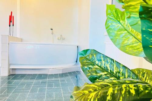 baño con bañera blanca y plantas verdes en Les chats maison, en Anzio
