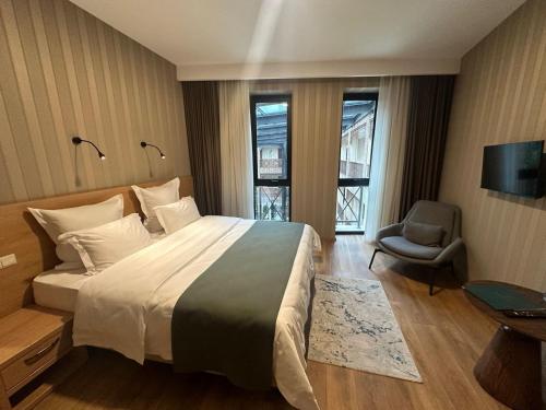 a hotel room with a large bed and a chair at Mukhrantubani Boutique Hotel in Tbilisi City