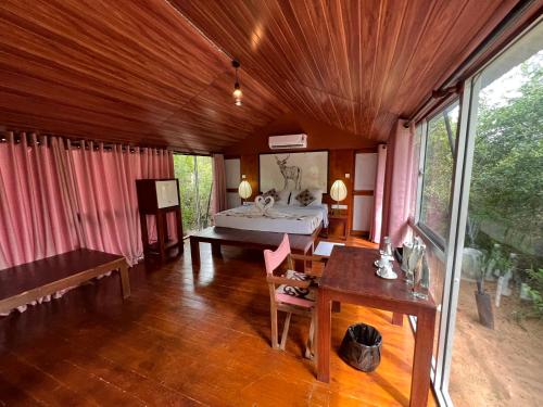1 dormitorio con 1 cama y 1 mesa en una habitación en Green Wild Yala - Luxury Camping & Free Safari Tour en Yala