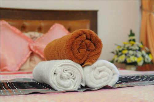 um urso de peluche sentado numa cama com toalhas em Serene Home em Demangan