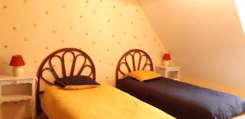 deux lits côte à côte dans une chambre dans l'établissement Gite de Kervao, Camélias, proche mer (800 mètres), meublé tourisme 3 étoiles, à Ploudalmézeau