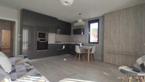una cocina con armarios negros, mesa y sillas en Central, brand new apart with parking, en Blagoevgrad