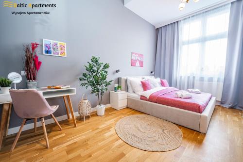 um quarto com uma cama, uma mesa e uma secretária em Baltic Apartments - Wisus em Świnoujście