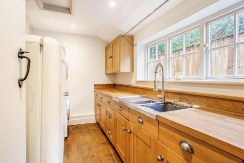 a kitchen with a sink and a refrigerator at The Little House in Thatcham