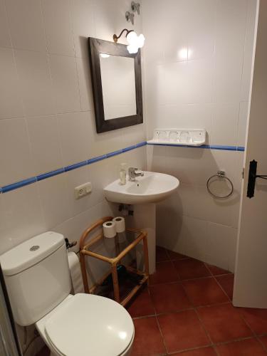 a bathroom with a white toilet and a sink at Turismo Rural Calaliu in Peratallada