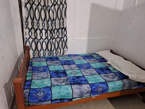 uma cama com uma colcha num quarto em Apple Homestay em Vagamon