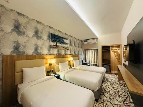 um quarto de hotel com duas camas e uma televisão em SKY PARK HOTEL em Dubai
