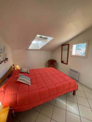 une chambre avec un lit rouge dans une pièce dans l'établissement 3CONV48- Charmant T2 avec vue imprenable en face plage Collioure, à Collioure