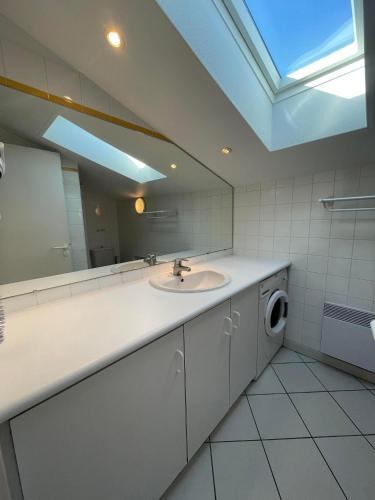 une salle de bain avec un lavabo et un miroir et une machine à laver dans l'établissement 3CONV48- Charmant T2 avec vue imprenable en face plage Collioure, à Collioure