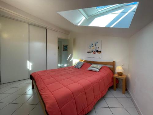 a bedroom with a red bed and a skylight at 3CONV48- Charmant T2 avec vue imprenable en face plage Collioure in Collioure