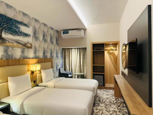 Habitación de hotel con 2 camas y TV en SKY PARK HOTEL, en Dubái