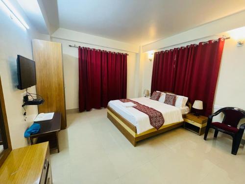 a hotel room with a bed and red curtains at STAR HOTEL in Srinagar