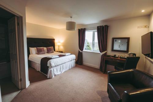 una camera d'albergo con letto e finestra di The Grange Hotel Brent Knoll a Highbridge