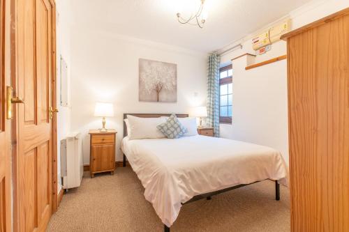 a small bedroom with a bed and a window at Tryfan Holiday Cottage in Llanfairpwllgwyngyll