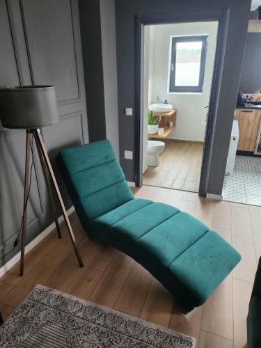 a living room with a green ottoman and a bathroom at Best View Terrace in Târgu-Mureş