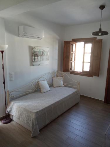 a bedroom with a bed and a window and a window at kominoshouses in Skala