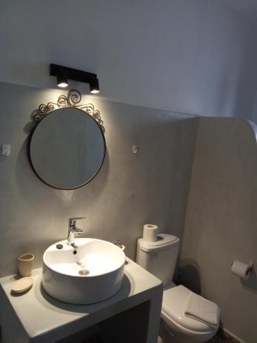 a bathroom with a sink and a mirror and a toilet at kominoshouses in Skala
