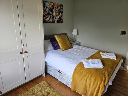 a bedroom with a bed with two towels on it at Oak House Laois B&B in Portarlington