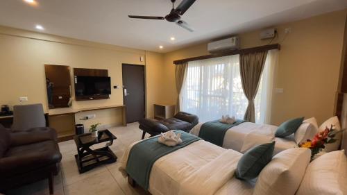 Hotel Banyan Tree Yeshwanthpur في بانغالور: غرفة فندقية بسريرين وتلفزيون