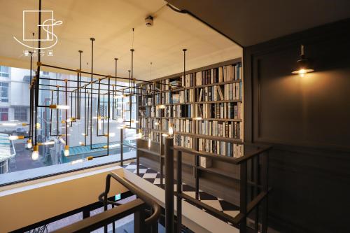 una biblioteca con estanterías de libros y una ventana en Konkai Inn en Tainan