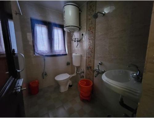 a bathroom with a sink and a toilet and a tub at Hotel Grand Abdullah, Pahalgam in Pahalgām