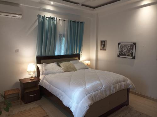 um quarto com uma cama grande e cortinas azuis em ADB Properties em Ogbojo