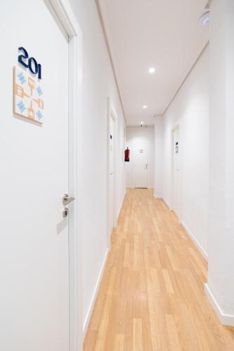 an empty hallway with white walls and wood floors at Hotel Alkazar in Valencia