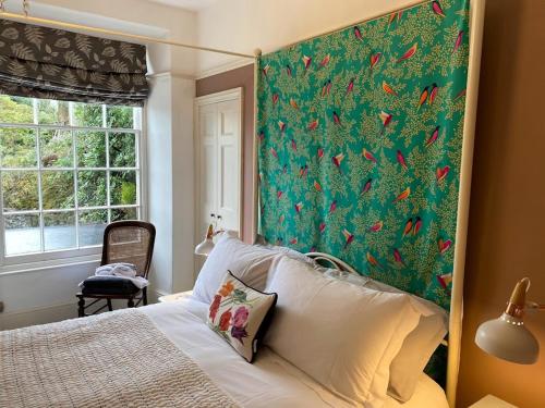 a bedroom with a bed with a large painting on the wall at Bryn Mair in Dolgellau