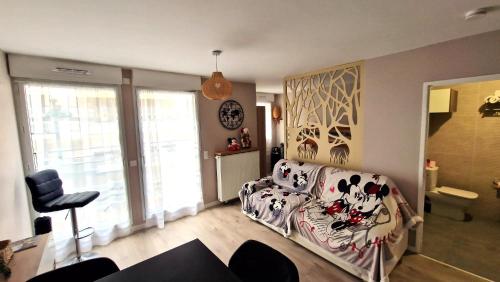uma sala de estar com um sofá e uma cadeira em Le Debussy 5 personnes, lit bébé, balcon, parking privé gratuit em Chessy