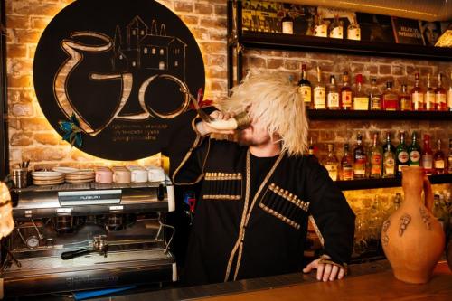 a man standing behind a bar talking on a microphone at Mildom Premium Hotel in Almaty