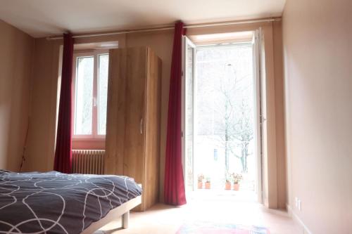 a bedroom with a bed and a large window at City Garni in Martigny-Ville