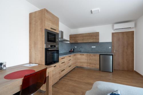 eine Küche mit Holzschränken und einem Holztisch mit einem Esszimmer in der Unterkunft Apartmány Pustiměř in Pustiměř