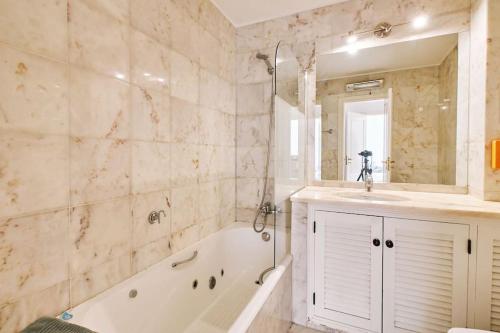 a bathroom with a tub and a sink and a bath tub at Apartment Tansy direkt am Meer in Porches