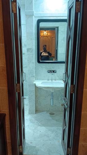 una persona que toma una foto de un baño con lavabo en Guulab Haveli - Opp Fort, en Jaisalmer