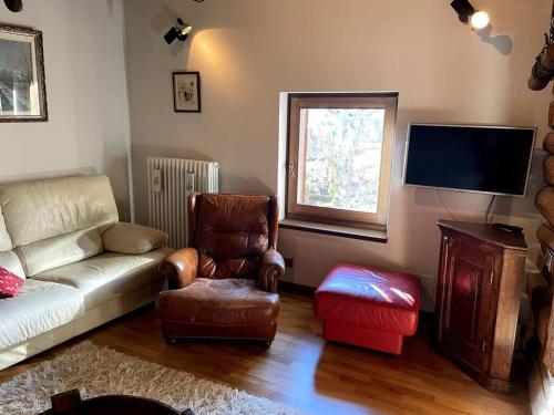 een woonkamer met een bank, een stoel en een tv bij Magnificent spacious 4 bedroom mountain chalet with spa in Antey-Saint-André
