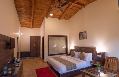 a bedroom with a large bed and a television at VOW HOTELS AND RESORTS in Belparāo