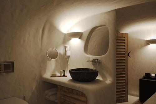 a bathroom with a bowl sink and a mirror at VILLA OIA 1880 in Oia