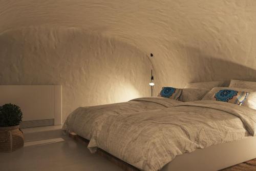 a bedroom with a large bed in a white room at VILLA OIA 1880 in Oia