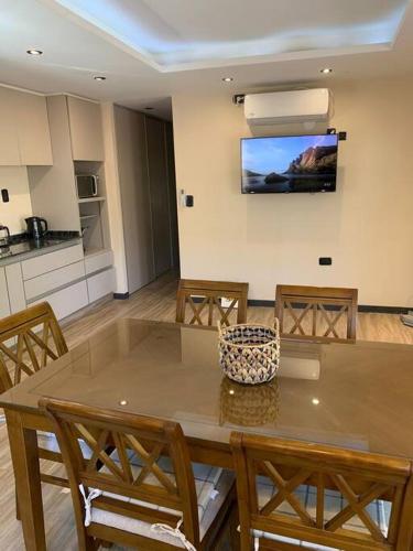 a dining room table with chairs and a television on the wall at Lujo, PS5 cerca de las mejores Bodegas + desayuno in Ciudad Lujan de Cuyo