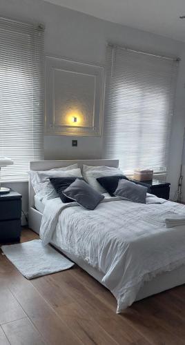 a bedroom with a large bed with white sheets and pillows at cally in London