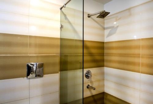 a shower with a glass door in a bathroom at Rainbow International Hotel Airport Zone Shamshabad in Shamshabad