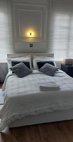 a large bed with white sheets and pillows at cally in London
