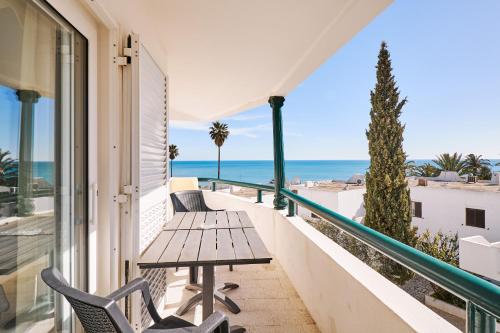 a balcony with a table and chairs and the beach at Apartment Tansy direkt am Meer in Porches