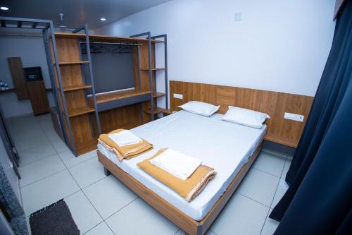 1 dormitorio con 1 cama y TV. en 24 CARAT STUDIO APARTMENTS, en Porbandar