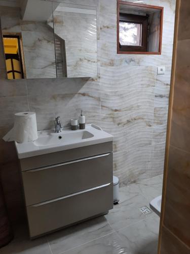 y baño con lavabo y espejo. en Casa Nicolas Busteni en Buşteni
